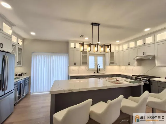 a kitchen with stainless steel appliances granite countertop a sink a stove and a refrigerator