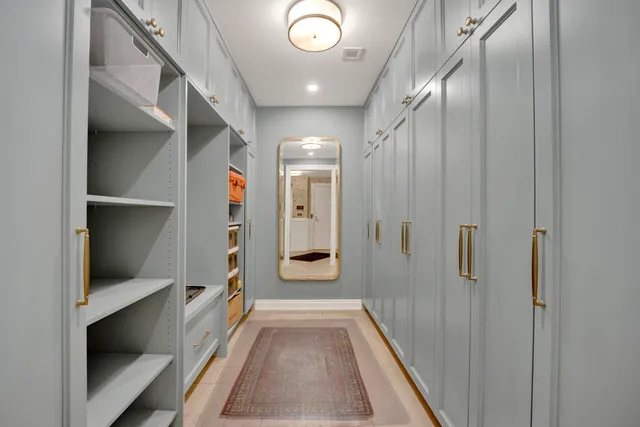 a hallway with white cabinets and wooden floor