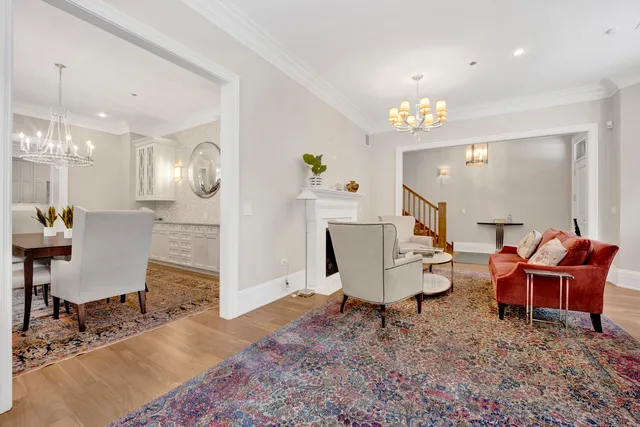 a dining room with wooden floor a chandelier a wooden table and chairs