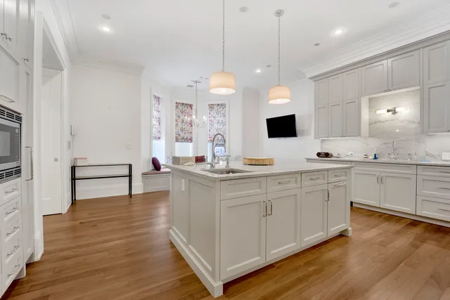 a kitchen with kitchen island granite countertop a table chairs sink and cabinets