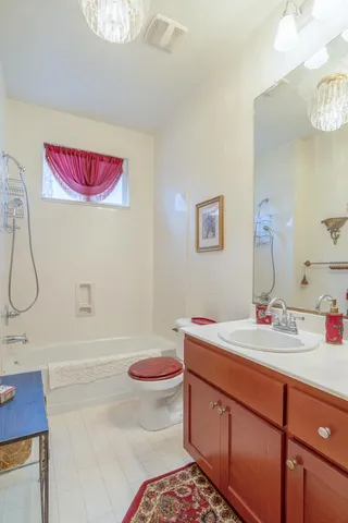 a bathroom with a sink mirror vanity and toilet