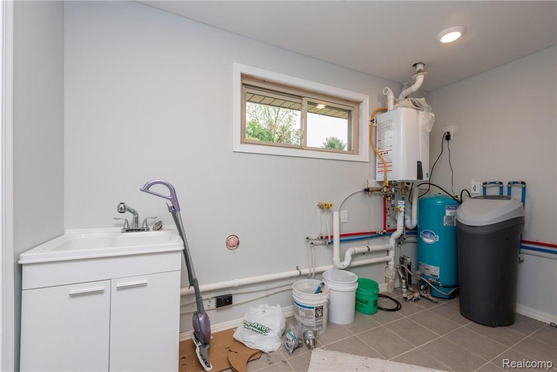 16017 Cavanaugh Lake Road Chelsea, MI 48118 - Photo 23 of 27 Laundry room with tankless water heater