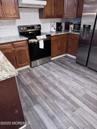 a kitchen with granite countertop a sink cabinets and stainless steel appliances