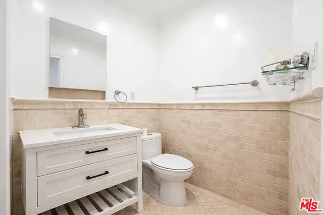 a bathroom with a toilet a sink and mirror