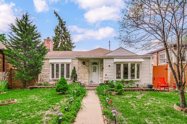 a front view of a house with a yard and potted plants