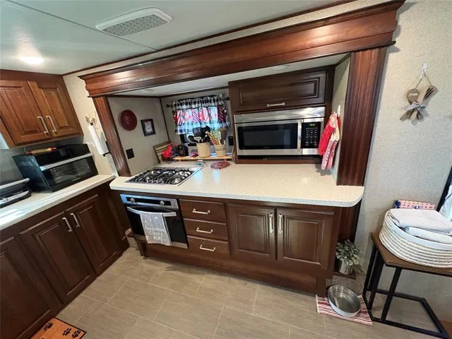 a kitchen with stainless steel appliances granite countertop a stove a sink and a microwave