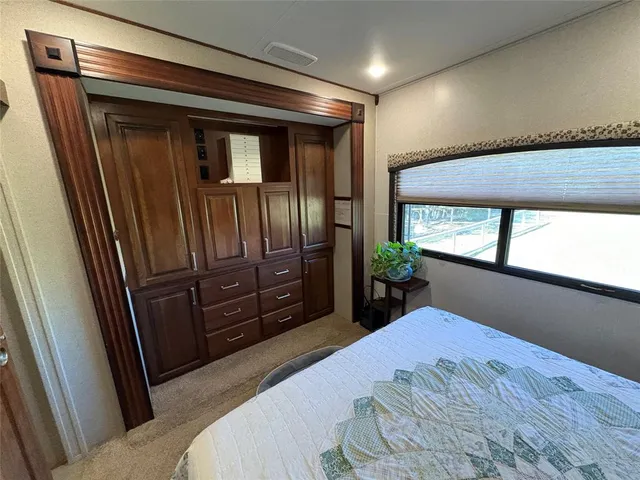 a bed sitting in a bedroom next to a window