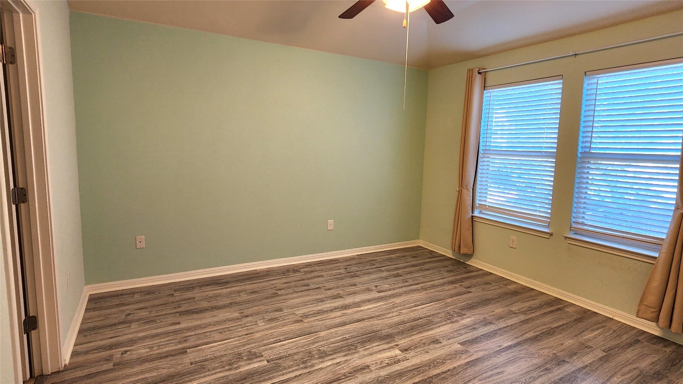 5432 Juniper Jct Lane Austin, TX 78744 - Photo 15 of 26 a view of an empty room with wooden floor and a window