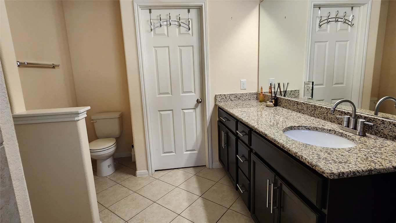 5432 Juniper Jct Lane Austin, TX 78744 - Photo 16 of 26 a bathroom with a granite countertop sink and a mirror