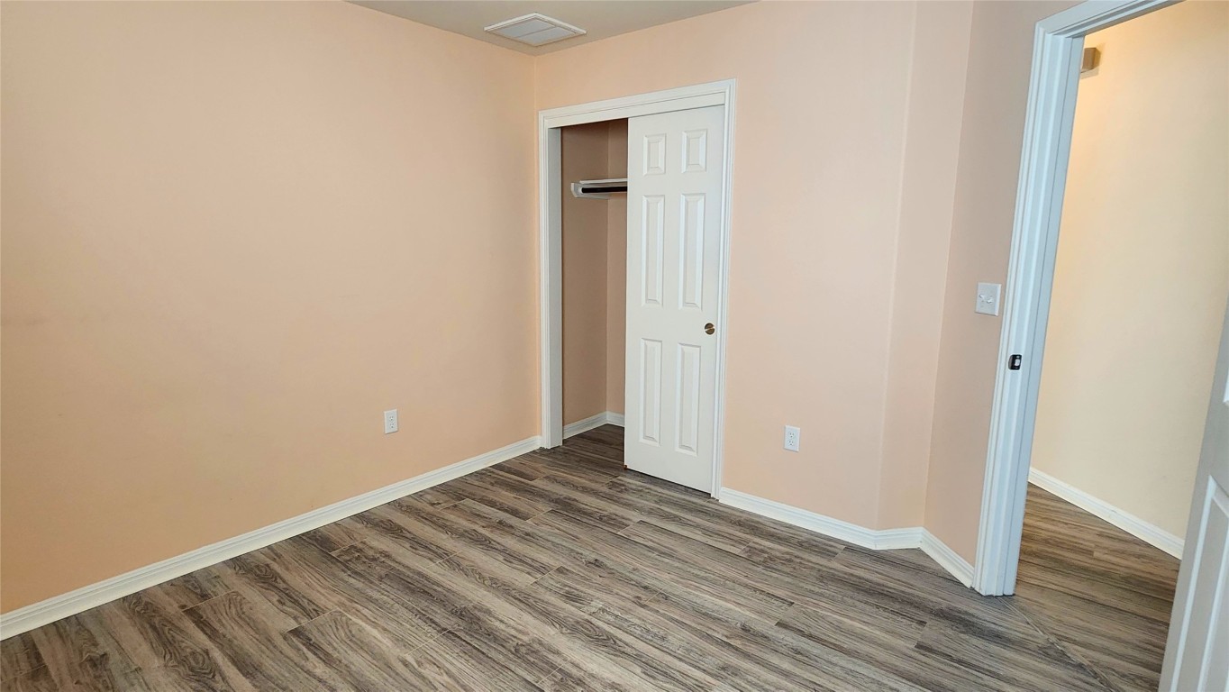5432 Juniper Jct Lane Austin, TX 78744 - Photo 20 of 26 a view of an empty room with wooden floor and a window