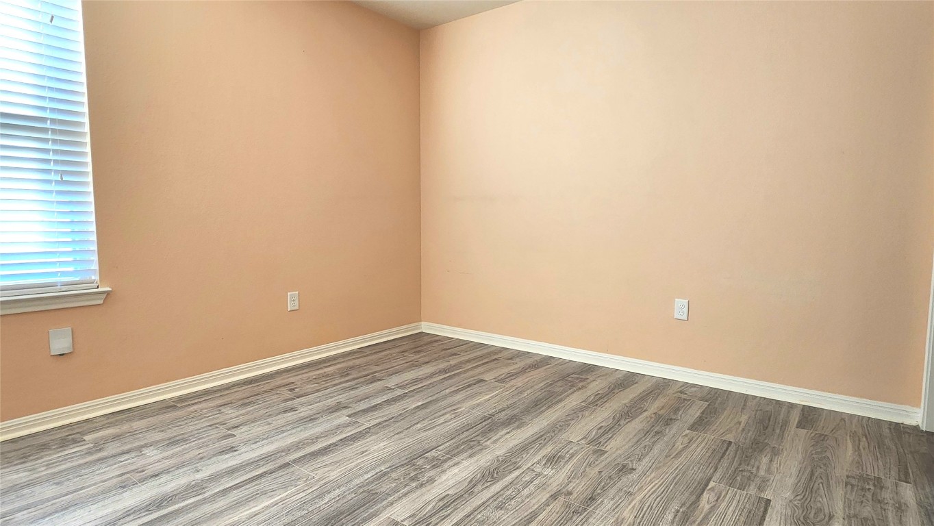 5432 Juniper Jct Lane Austin, TX 78744 - Photo 21 of 26 a view of an empty room with wooden floor and a window