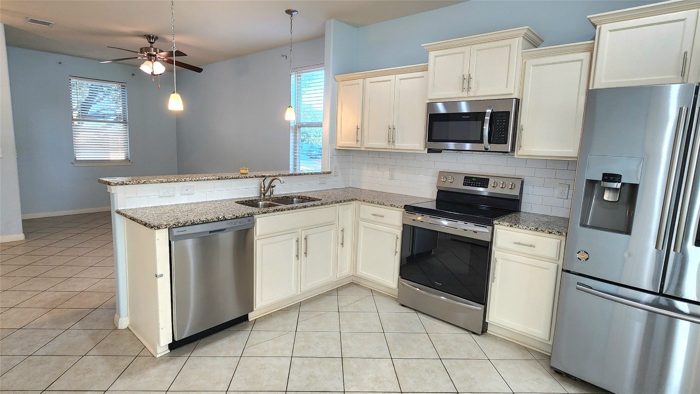 5432 Juniper Jct Lane Austin, TX 78744 - Photo 6 of 26 a kitchen with white cabinets stainless steel appliances and sink