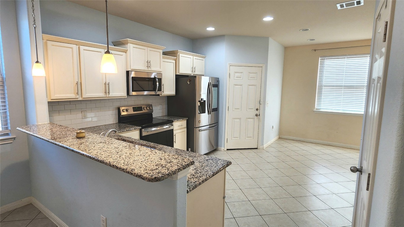5432 Juniper Jct Lane Austin, TX 78744 - Photo 8 of 26 a kitchen with stainless steel appliances granite countertop a sink and a stove