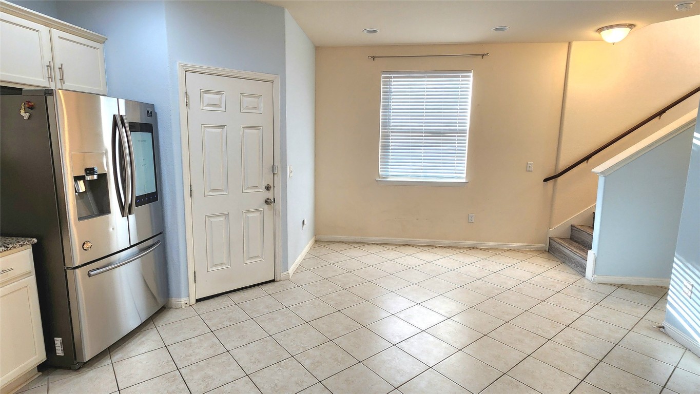 5432 Juniper Jct Lane Austin, TX 78744 - Photo 9 of 26 a view of a refrigerator in kitchen and white cabinets