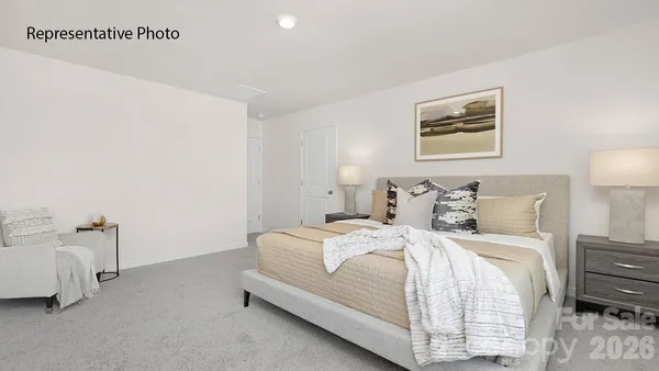 a bedroom with a bed and a lamp on dresser