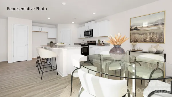 a kitchen with stainless steel appliances kitchen island granite countertop a microwave a stove and white cabinets