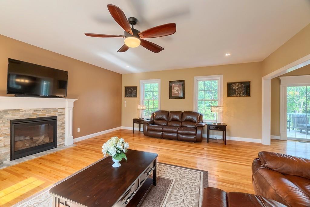 16 Mockingbird Hill Road Groton, MA 01450 - Photo 18 of 41 a living room with furniture a fireplace and a flat screen tv