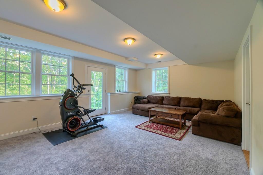 16 Mockingbird Hill Road Groton, MA 01450 - Photo 30 of 41 a living room with furniture a window and gym cycle