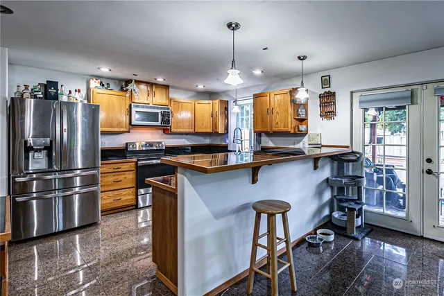 a kitchen with stainless steel appliances granite countertop a sink stove and refrigerator