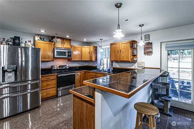 a kitchen with stainless steel appliances granite countertop a refrigerator microwave and sink