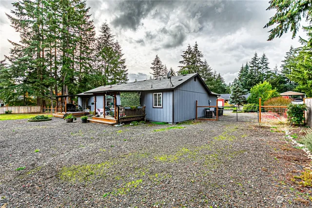 a view of a house with a yard and large tree