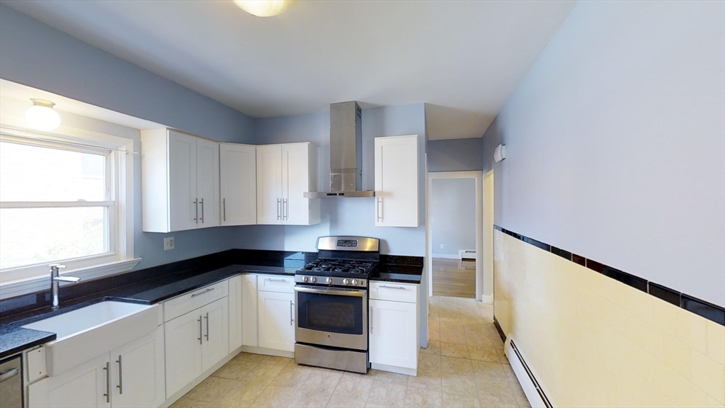 a kitchen with stainless steel appliances a sink stove and cabinets