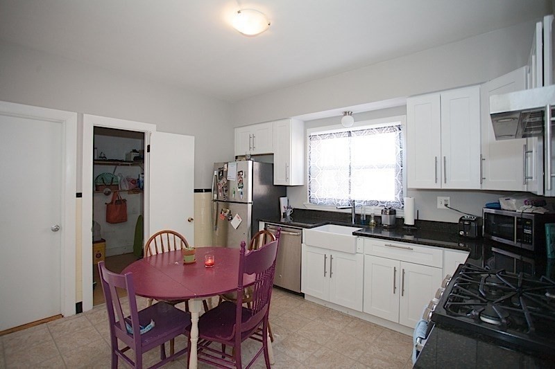 18 Murdock Street, Unit 1 Somerville, MA 02145 - Photo 2 of 10 a kitchen with stainless steel appliances a sink a stove a table and chairs