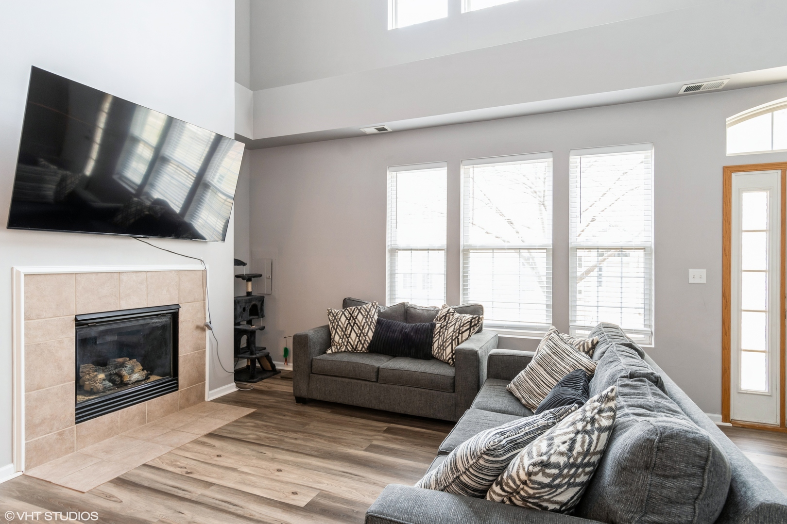 237 Springbrook Trail South, Unit 3 Oswego, IL 60543 - Photo 3 of 17 a living room with furniture a flat screen tv and a fireplace