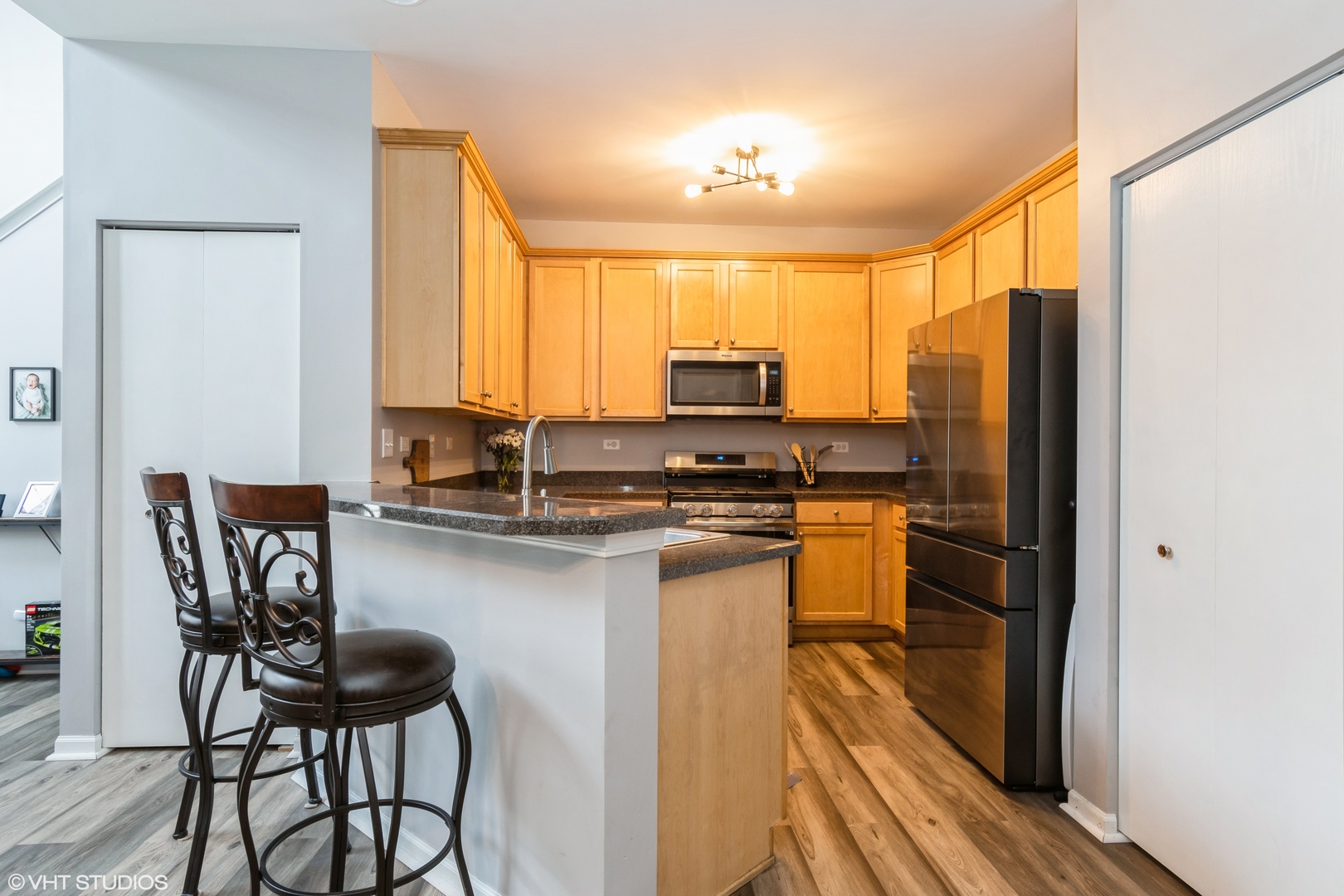 237 Springbrook Trail South, Unit 3 Oswego, IL 60543 - Photo 5 of 17 a kitchen with stainless steel appliances a microwave a sink and white cabinets