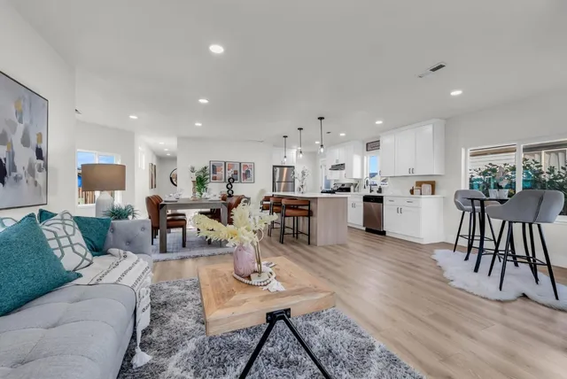 a dining hall with stainless steel appliances kitchen island a table and chairs in it