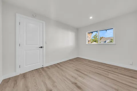 a view of a hallway with wooden floor and staircase