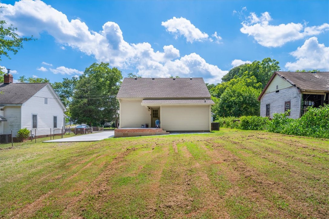 1102 West End Avenue Anderson, SC 29625 - Photo 28 of 28 A deep backyard with a concrete driveway leading to the back entrance of this home.