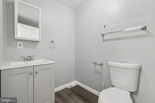 a bathroom with a toilet a sink and mirror