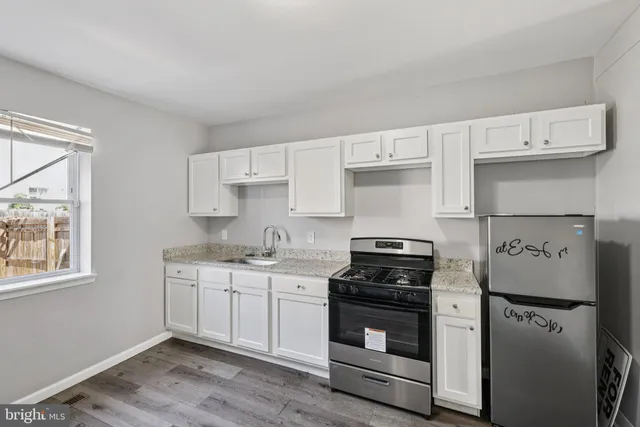 a kitchen with cabinets appliances and a window
