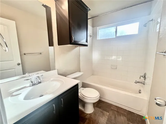 a bathroom with a bathtub shower sink vanity and toilet