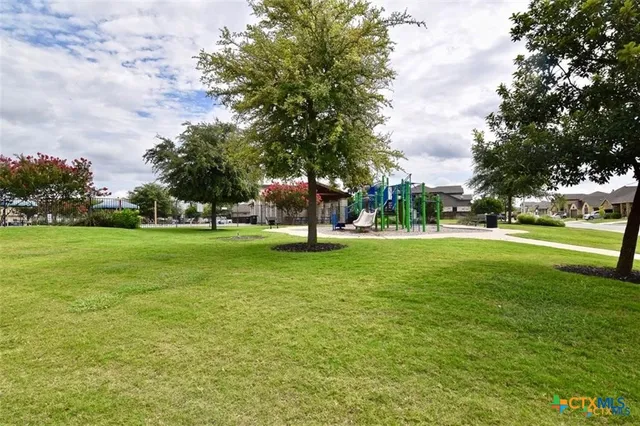 a view of a park with swings and trees