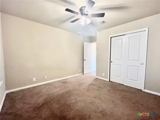 an empty room with a ceiling fan and a chandelier fan