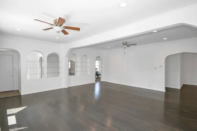 a view of empty room with wooden floor and ceiling fan