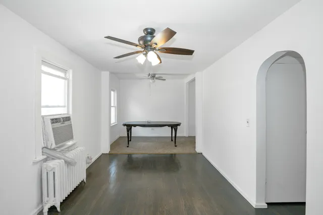 a view of a livingroom with wooden floor and a ceiling fan