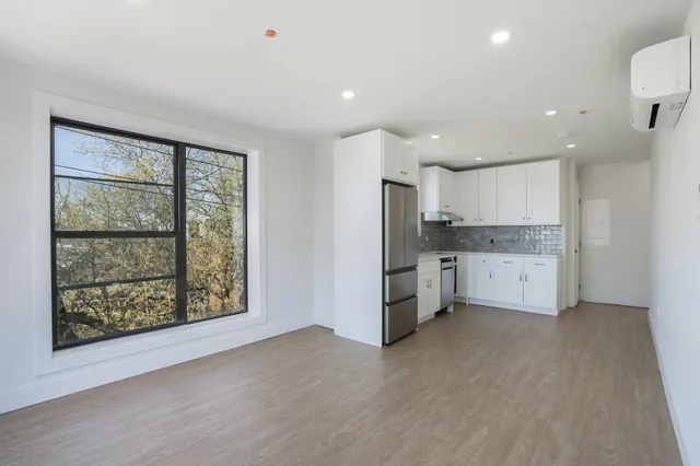 a view of a kitchen with a refrigerator and a window