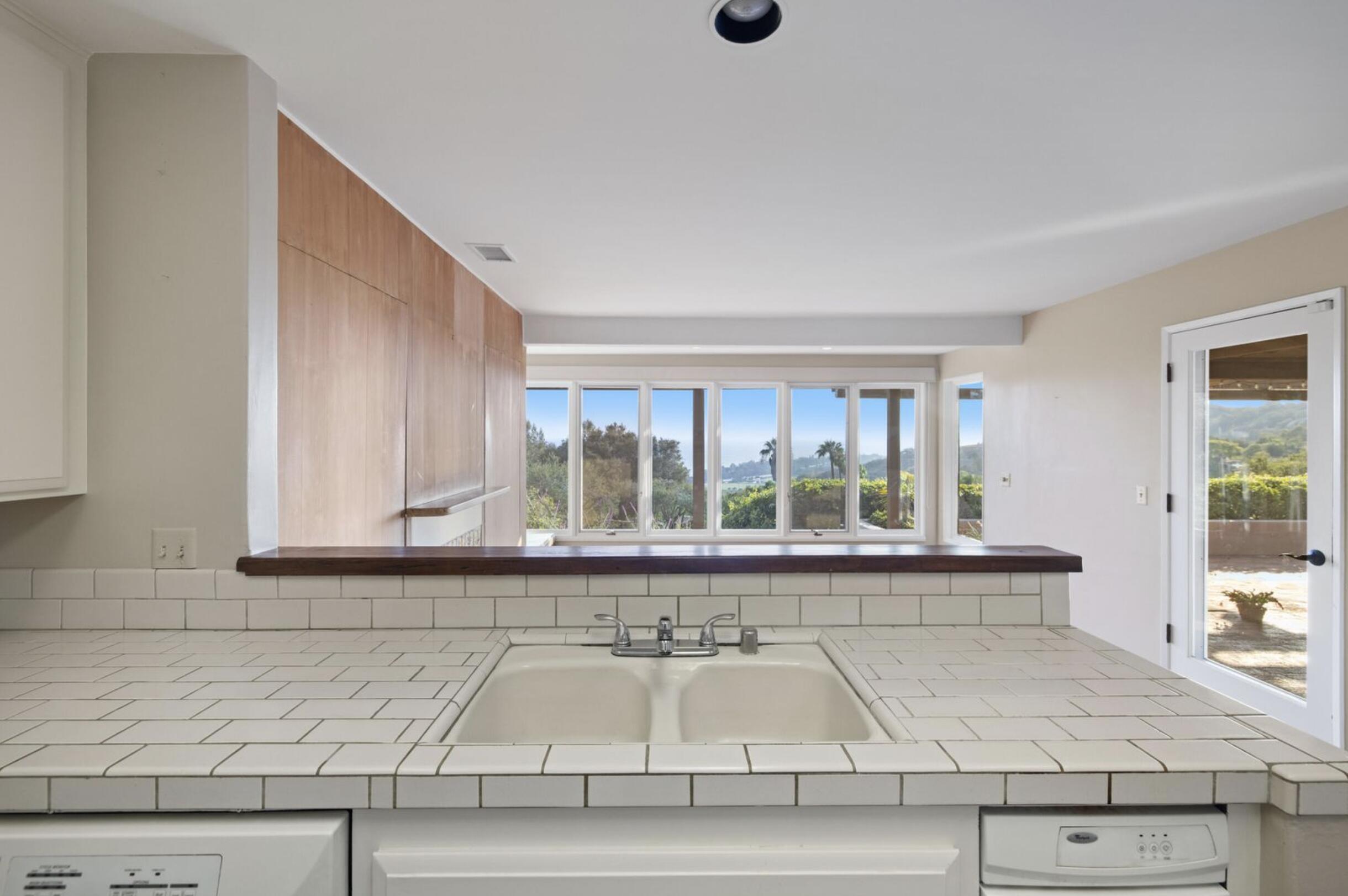1986 Arriba Street Carpinteria, CA 93013 - Photo 11 of 28 a bathroom with a granite countertop sink and a large mirror