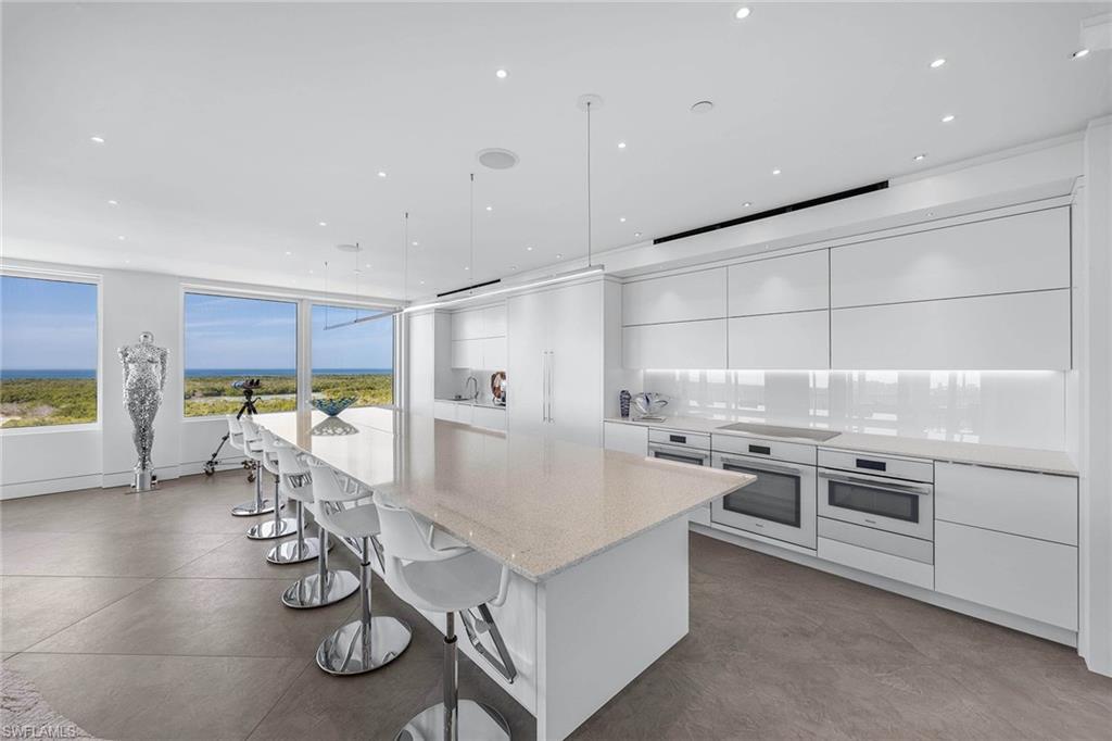 425 Dockside Drive, Unit 905 Naples, FL 34110 - Photo 13 of 50 a kitchen with stainless steel appliances granite countertop a stove and a refrigerator