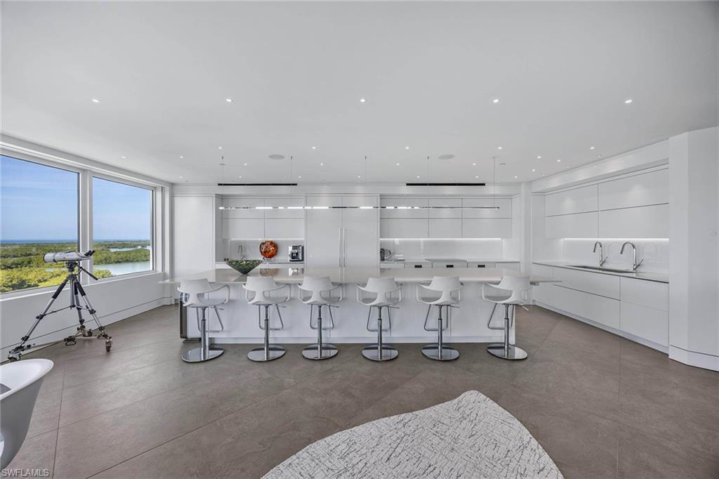 425 Dockside Drive, Unit 905 Naples, FL 34110 - Photo 14 of 50 a living room with furniture a window and gym equipment