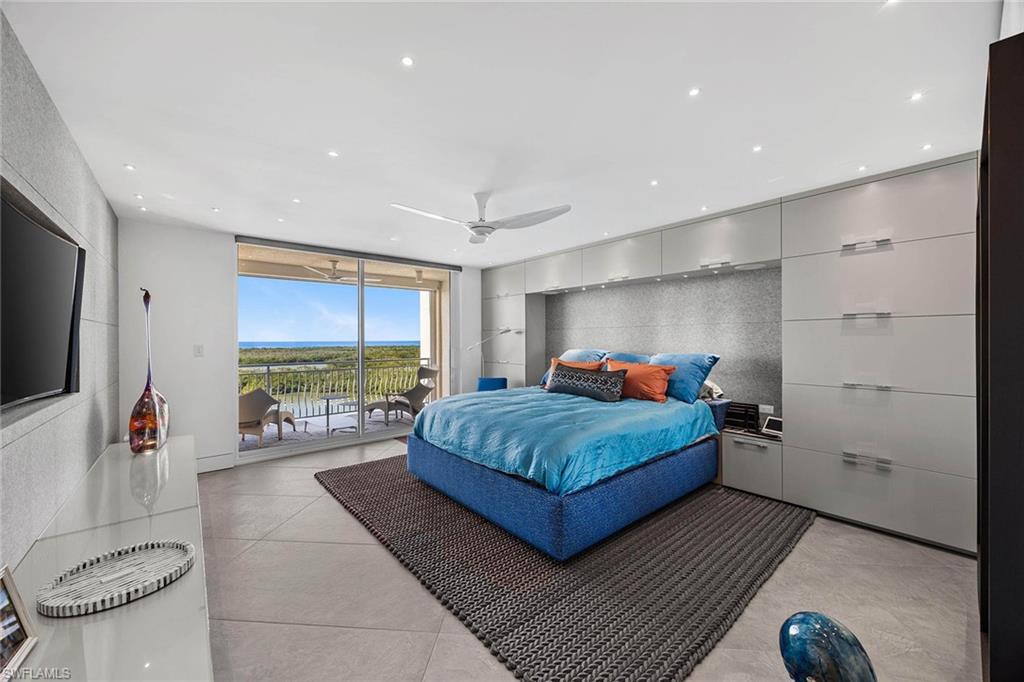 425 Dockside Drive, Unit 905 Naples, FL 34110 - Photo 19 of 50 a bedroom with a bed and a flat screen tv