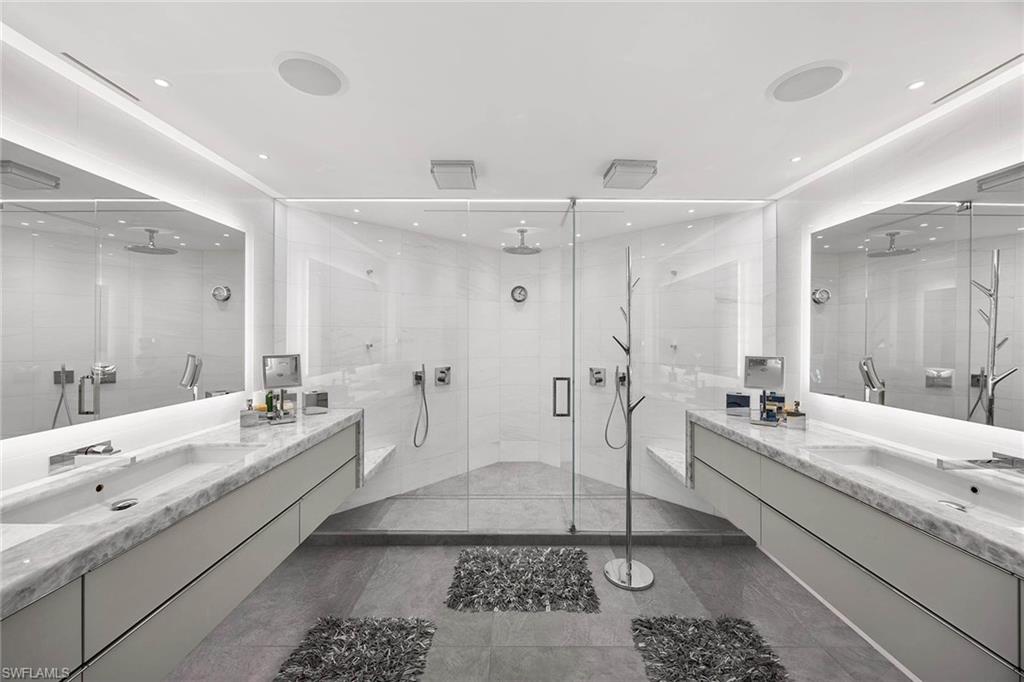 425 Dockside Drive, Unit 905 Naples, FL 34110 - Photo 22 of 50 a bathroom with a double vanity sink a mirror and a bathtub