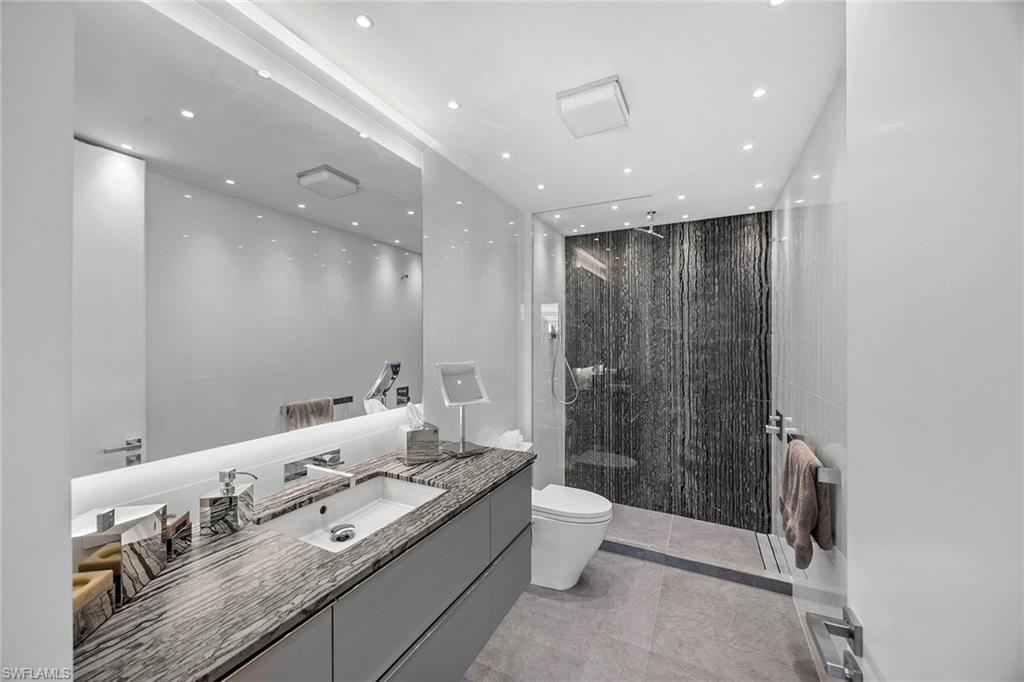 425 Dockside Drive, Unit 905 Naples, FL 34110 - Photo 25 of 50 a large bathroom with a granite countertop sink a toilet and shower