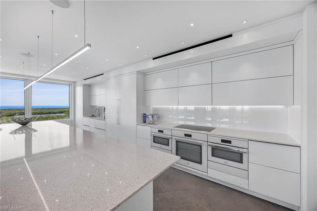 425 Dockside Drive, Unit 905 Naples, FL 34110 - Photo 46 of 50 an open kitchen with white cabinets and stainless steel appliances