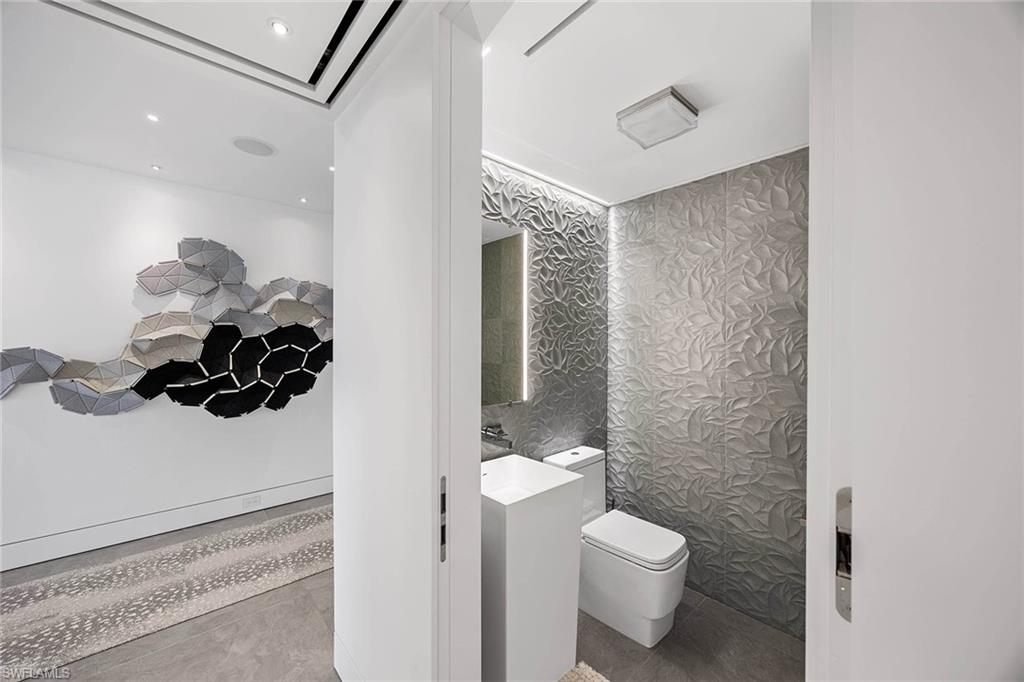 425 Dockside Drive, Unit 905 Naples, FL 34110 - Photo 49 of 50 a bathroom with a toilet a sink and mirror