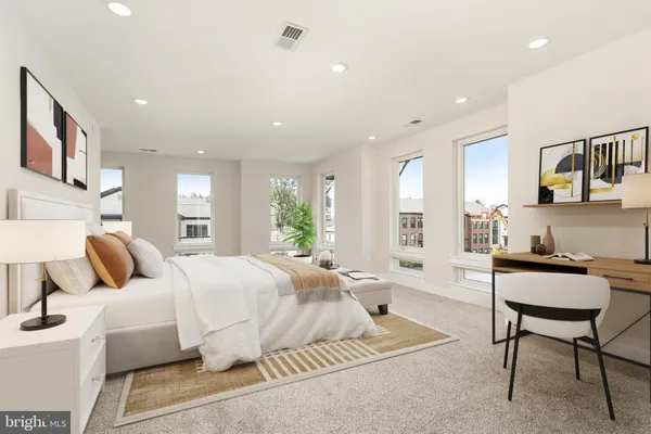 a bedroom with a bed a table and chair with the wooden floor