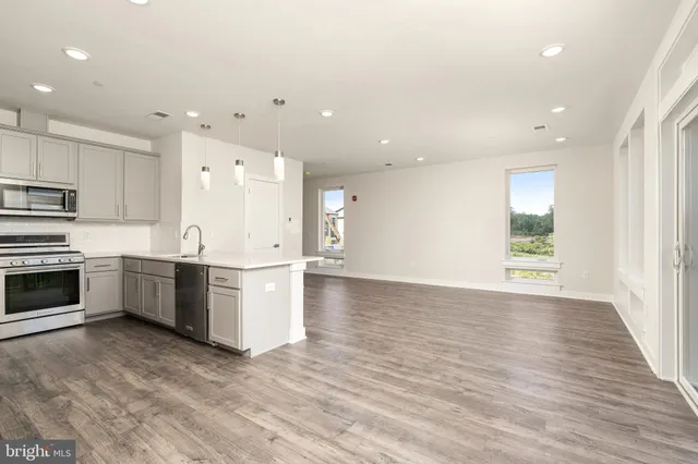 a view of kitchen with wooden floor and electronic appliances